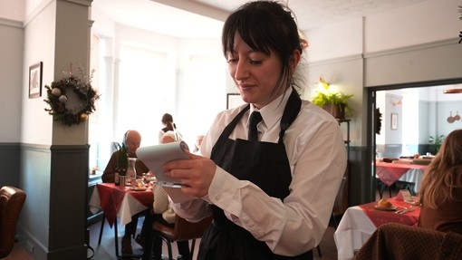 A student at front of house taking down an order on a pad