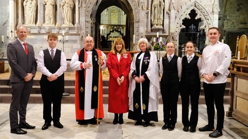 Inside St David's a line of church dignitaries with Sarah Edwards and college students
