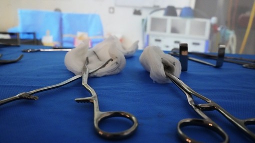 Forceps on a table (close up) with sutures in them