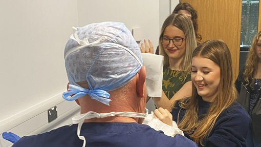 The back of the trainer helping students to scrub up