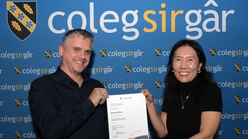 An Access student holding a certificate with tutor Nick Fry