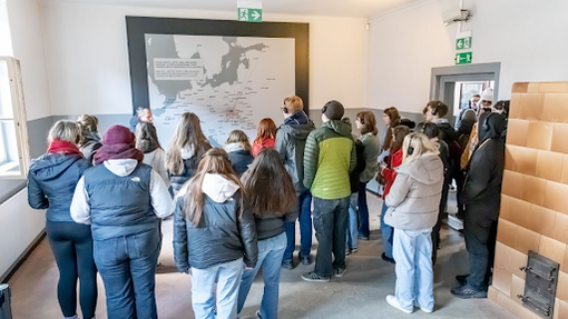 Young people looking at a map inside a building at the camp museum