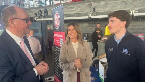 The team in the Senedd with an apprentice talking to a dignitary 