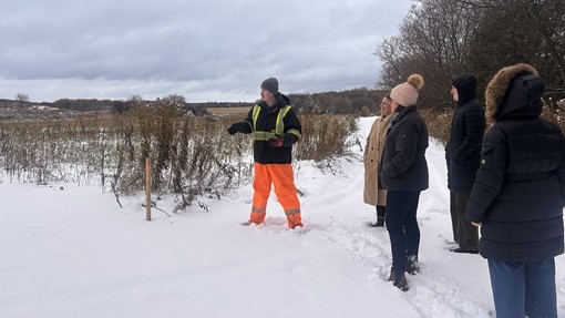 Staff out in the snow being shown an agri system