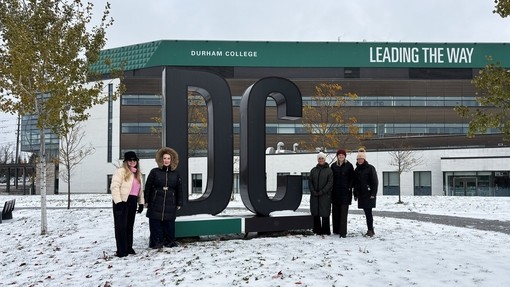 Staff outside Durham College (sign)
