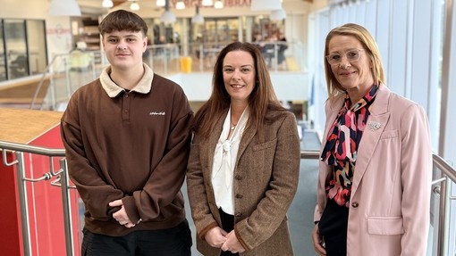 Ioan with the minister and a vice principal on the second floor with beams on the ceiling