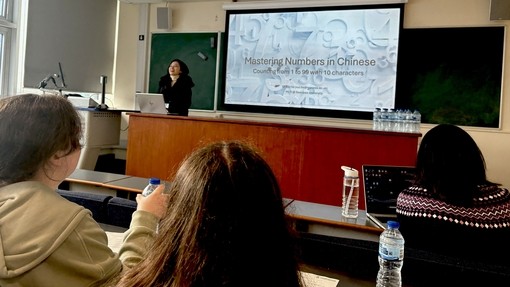 Students in a classroom with a screen with Mandarin language