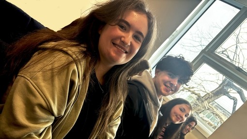 Students in a row in a classroom looking relaxed and happy