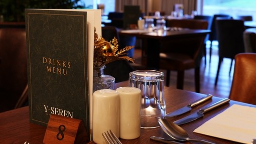 Second Prize a picture of a table top close up with menu, cutlery, condiments and a blurred restaurant in the background