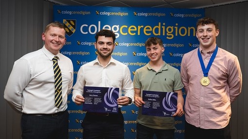A group of male students with tutors holding their medals