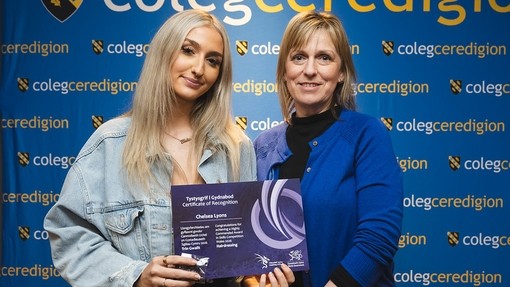 A student holding a certificate of recognition 