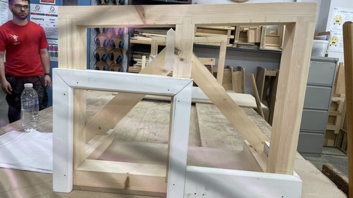 A student with his joinery work (like a timber frame)