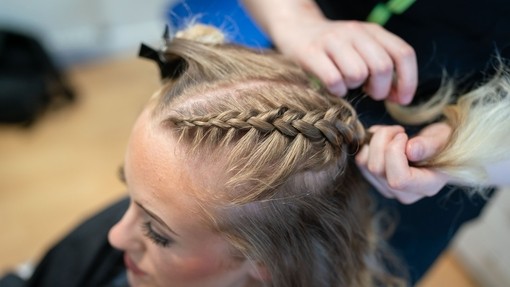 Close up of a young lady having her hair put in a french braid