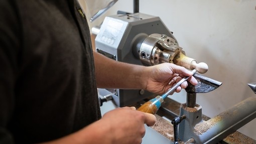 image of a young man in black using a wood turner
