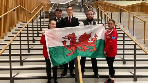 Some of Sam's competitors on a steps holding the Welsh flag