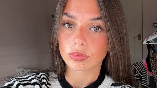 A selfie of Ava Martin wearing a black and white striped top