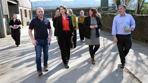 The minister walking around on a campus tour with a number of college staff