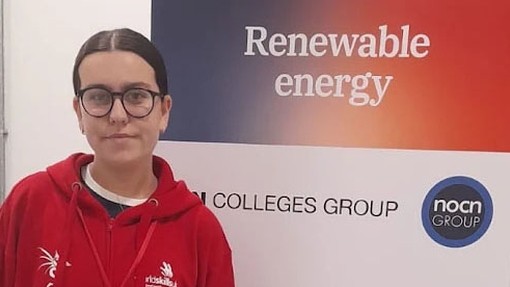 Emily head shot with the words renewable energy on a roller banner behind her
