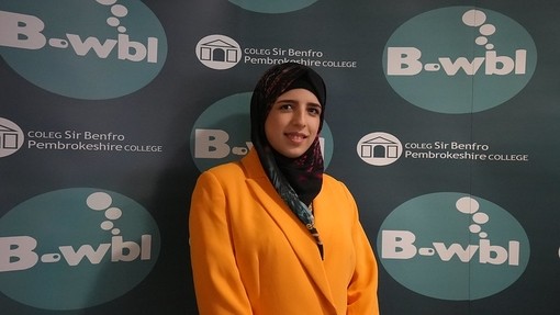Fatima wearing a head covering standing in front of Bwbl branding