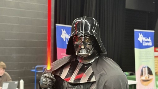 Darth Vader looking at the camera holding a light saber