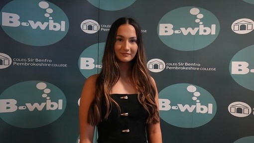 Lilly in a dress standing in front of Bwbl branding