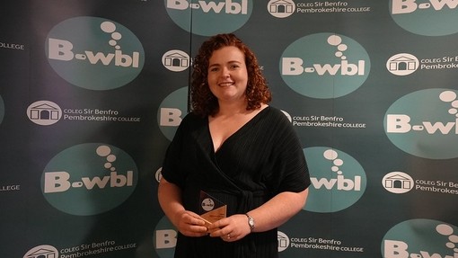 Siriol in a dress standing in front of Bwbl branding