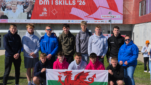 Students with a Welsh flag in front of a banner saying skills (a banner for the event)