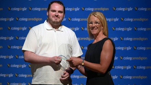 A senior staff member awarding a mature student