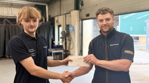 The winner with a representative from New Holland