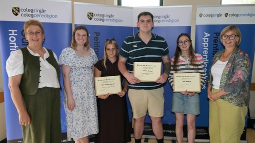 A group of students being presented awards by staff