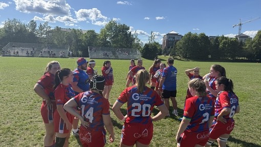 The girls team talking on a field in kit