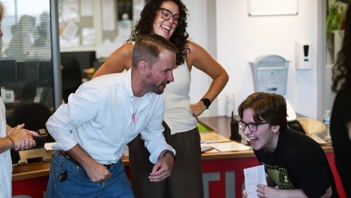 A student looking thrilled with a member of staff joining in