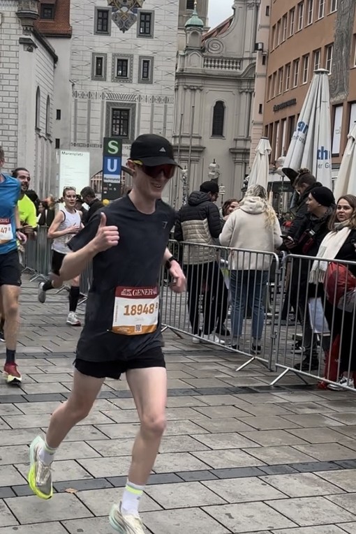 Owain Gravell running in Munich half marathon giving a thumbs up