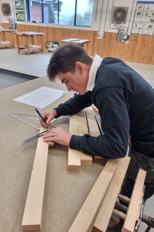 One of the competitors working with wood and tools