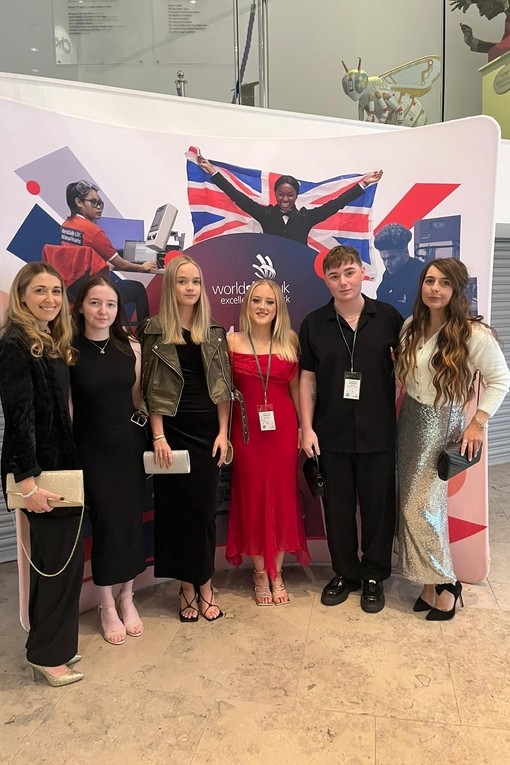 A group of students dressed smartly in front of a national winners stand