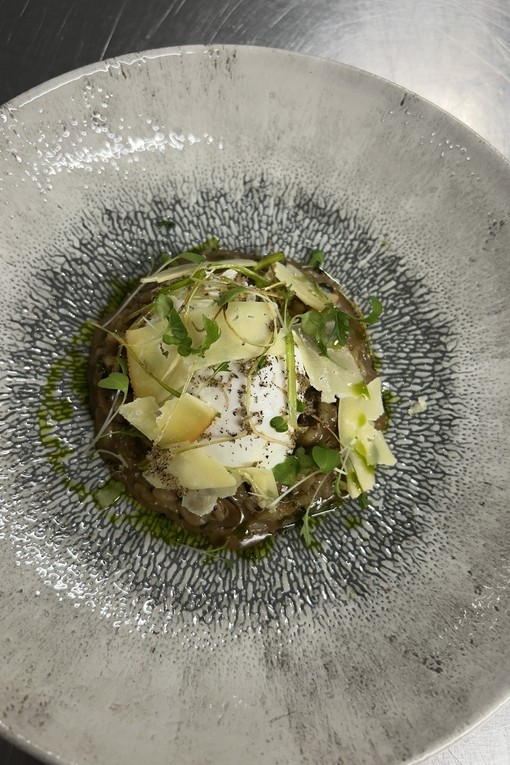 A risotto dish by one of the students presented nicely on a white dish with a blue tint