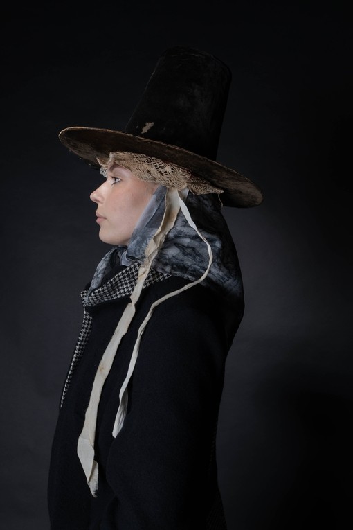 A woman looking sideways wearing a traditional Welsh hat, a nod to tradition in a contemporary style