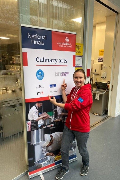 A competitor pointing to a promotional banner with the competition category name