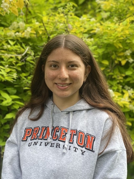 Hannah in front of some greenery wearing a Princeton hoodie