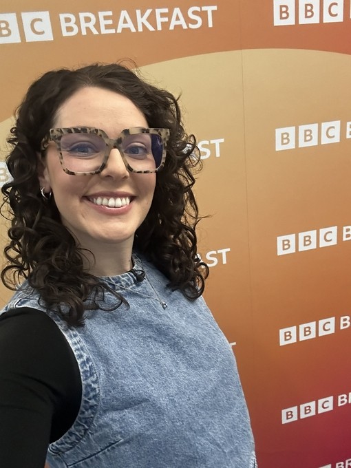Georgia taking a selfie in front of the BBC branding 