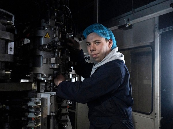 A young apprentice student working on an industrial machine whilst on placement.