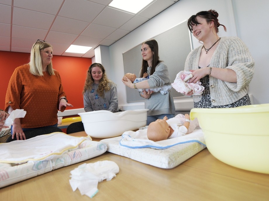 Students practice nursing a baby.
