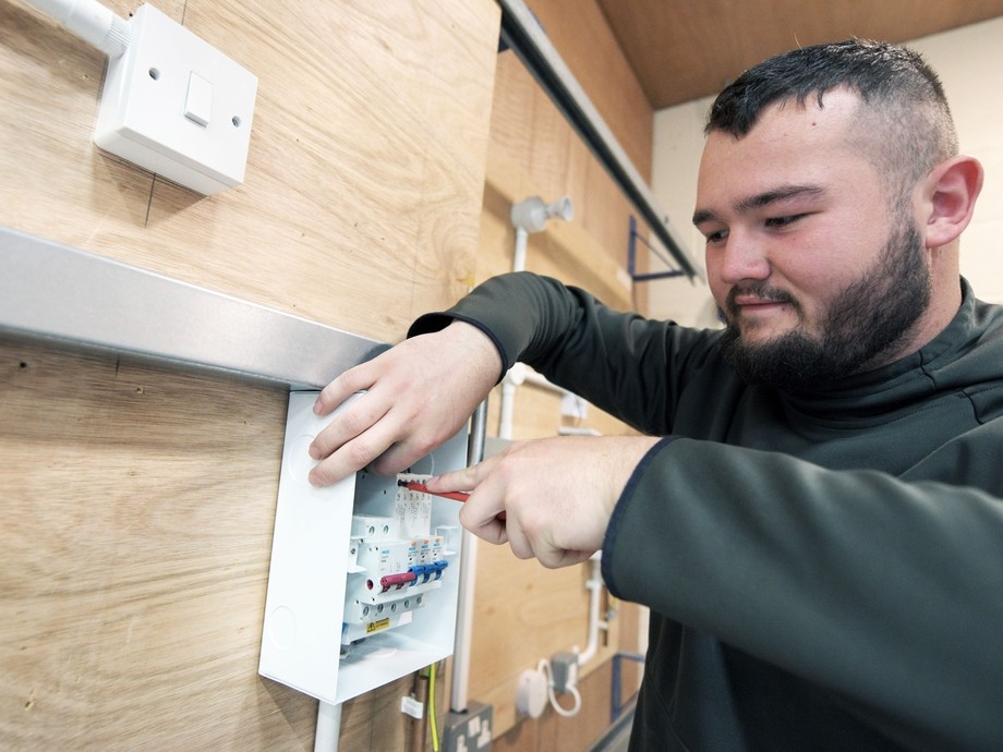 A student wires an electrical box.