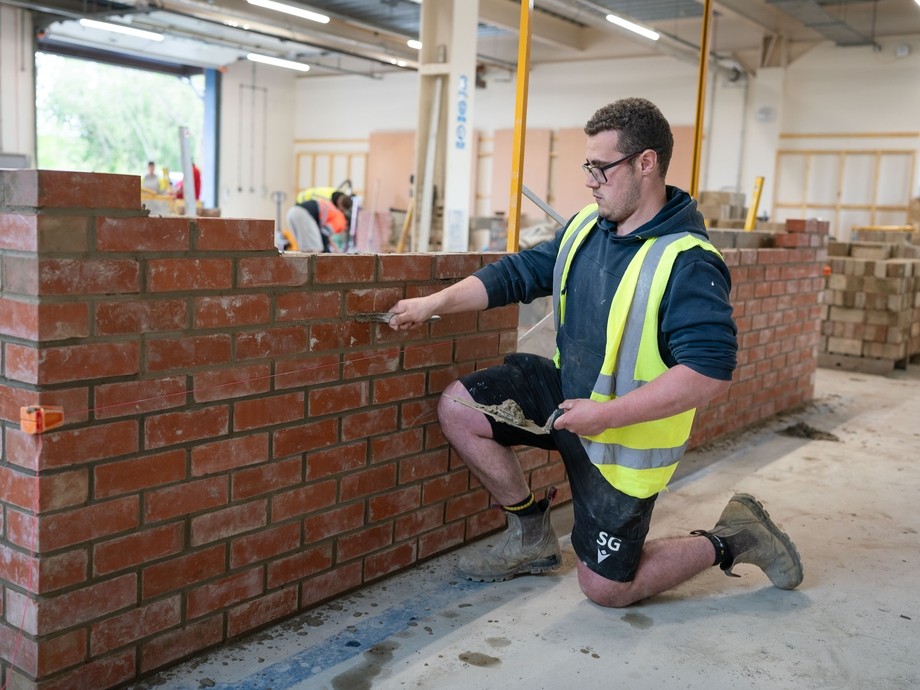 Student laying bricks in workshop