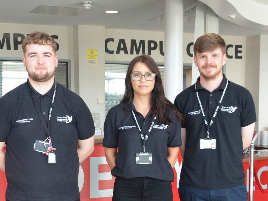 Three council employees standing by the college reception
