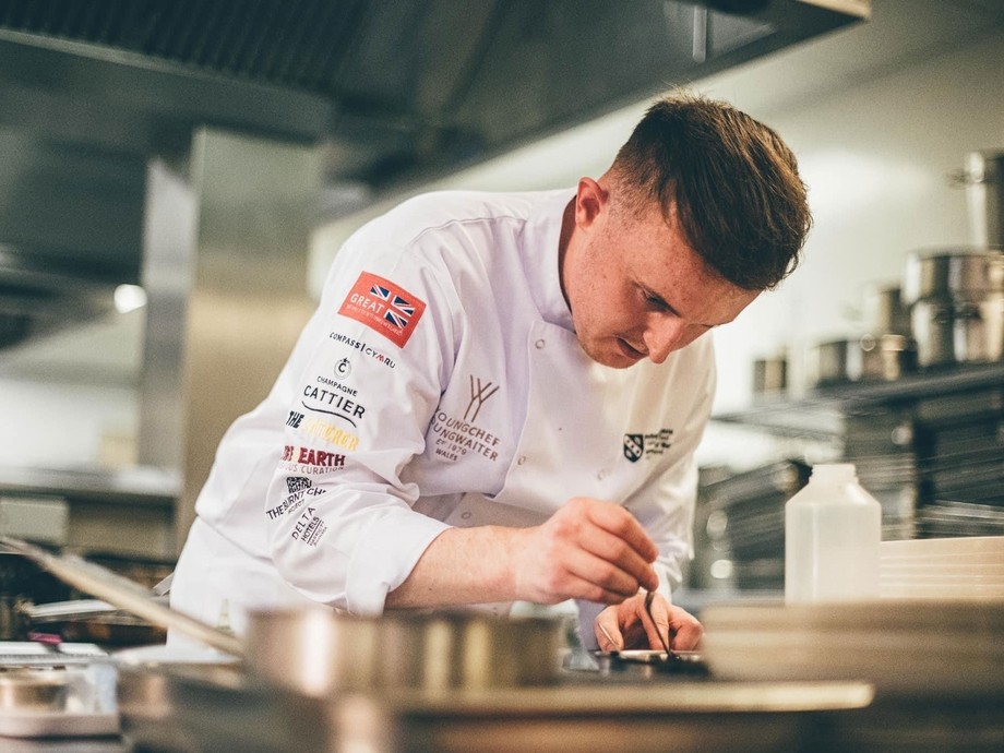 Sam in the kitchen putting final pieces to his dish