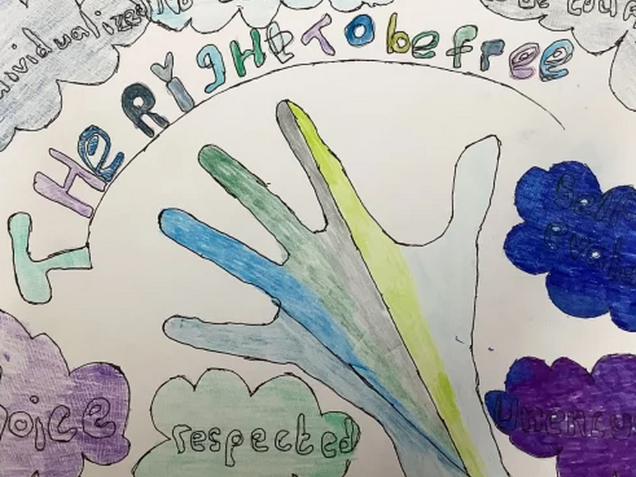 A drawing: 'The Right to be Free' is written on a poster with a hand reaching out