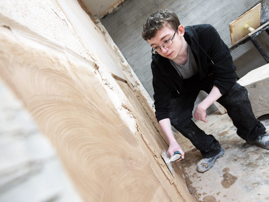 Student plastering wall