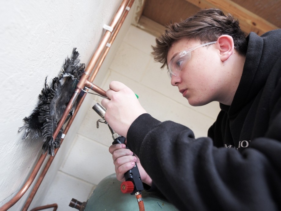 student welding pipes
