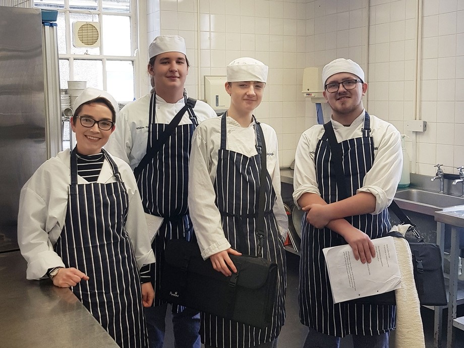 a group wearing chefs outfits with the GCSE tutor 
